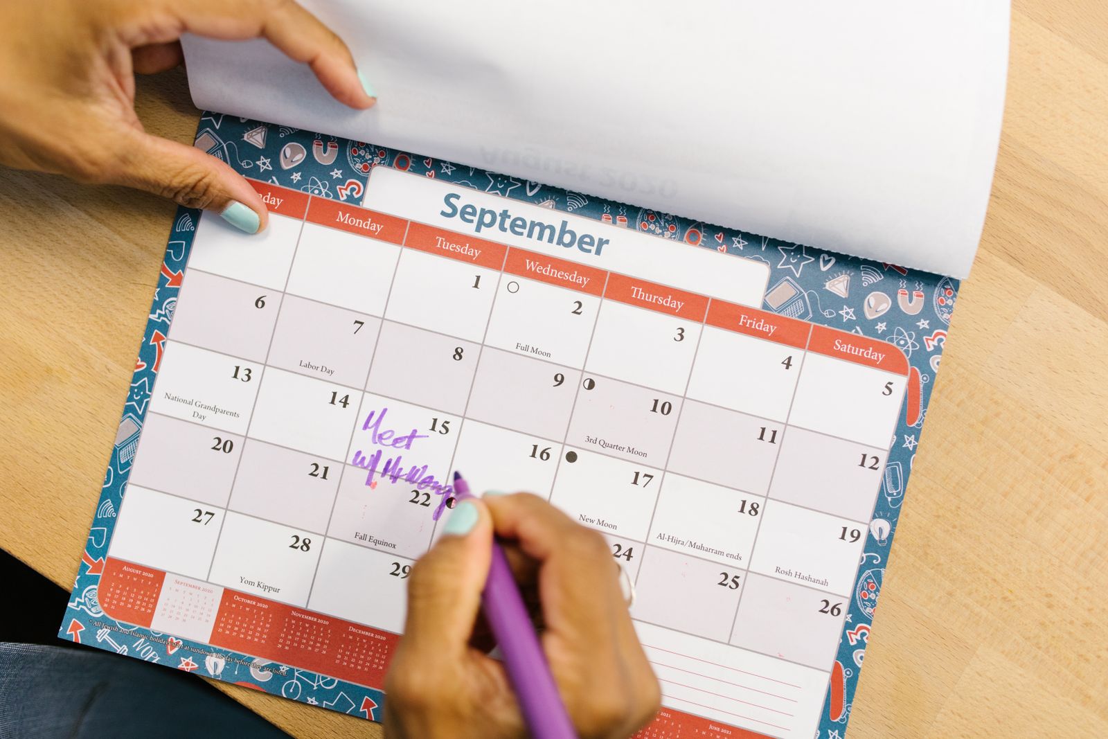 Personne marquant un jour férié sur un calendrier de bureau