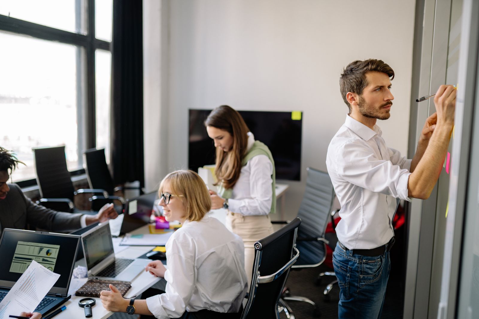 Manager ajustant le planning de son équipe devant un tableau de bureaux