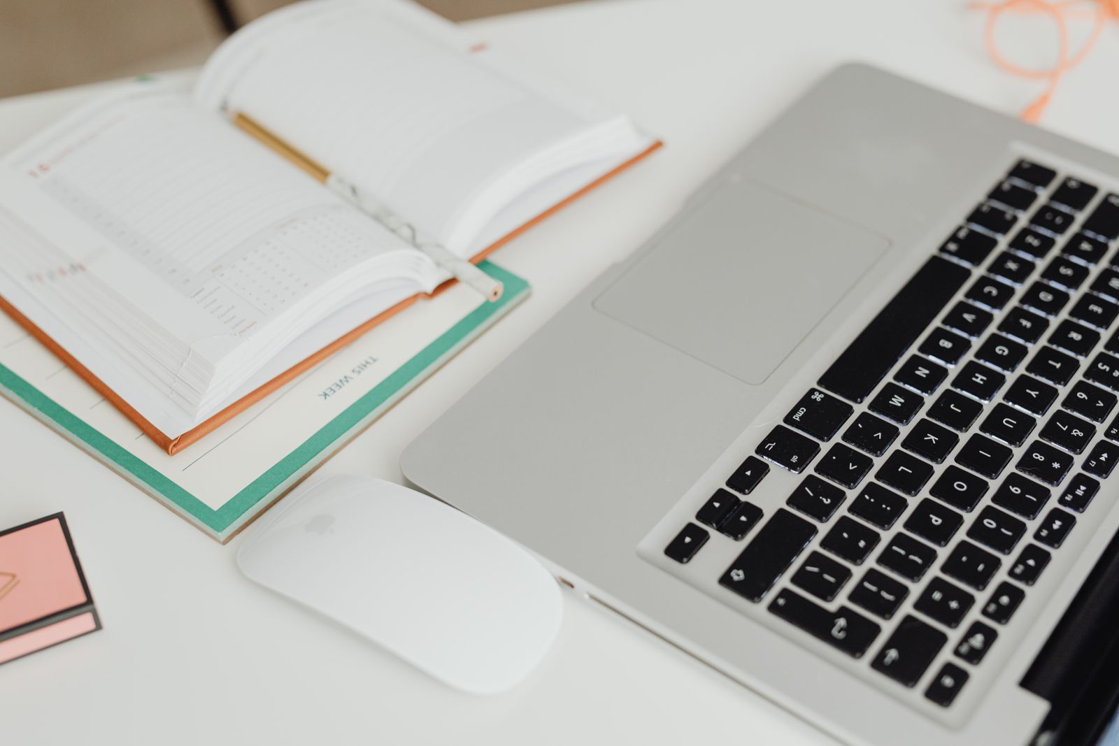 Espace de travail organisé avec agenda ouvert et ordinateur portable, vue de dessus